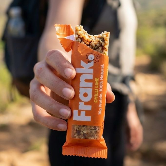 Person on hike taking a break to have a Frank Protein Bar